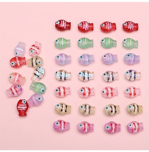 Macro shot of 14x10mm hand-painted glass fish beads in various colors for DIY jewelry