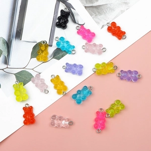 Détail macro de breloques oursons en résine colorée avec anneaux pour bijoux DIY