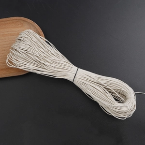 Close-up of 1mm cream woven wax cotton cord for DIY jewelry on a dark texture background