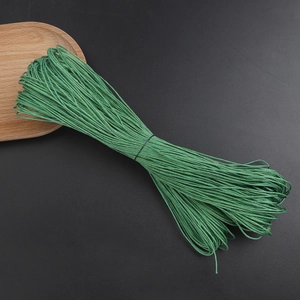 Detail of 1mm green waxed cotton cord bundle for handmade DIY jewelry on textured background