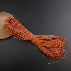 Detailed close-up of 1mm orange waxed cotton cord bundle for DIY jewelry weaving
