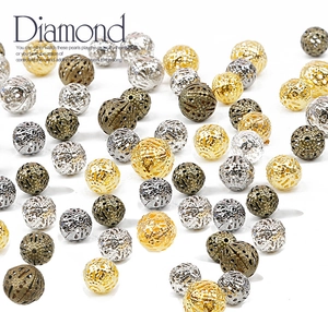 Macro détaillée de perles métalliques filigranes creuses en or, argent et bronze