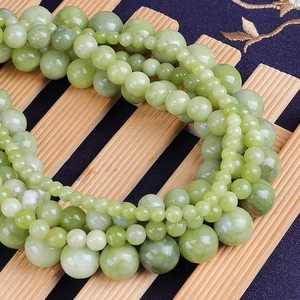 Macro view of natural green jade beads showing smooth texture and various diameters