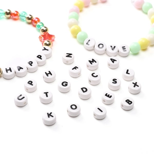 Close-up of DIY ceramic alphabet beads showing HAPPY and LOVE words on bracelets