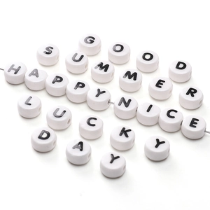 Detail view of round white ceramic letter beads for DIY jewelry making and bracelets