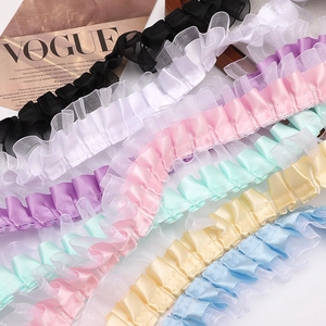 Detailed macro view of multi-colored double-layered pleated lace ribbons for DIY crafts