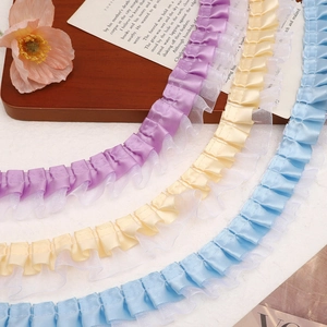 Macro detail of double-layer pleated lace ribbon in purple, yellow, and blue colors