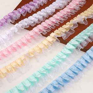 Detail of colorful double-layered pleated lace ribbons in satin and organza