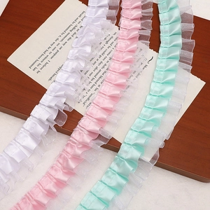 Detailed macro view of white pink and mint green double layered pleated lace ribbons