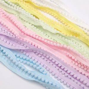Close-up of rainbow macaron pom-pom trim for DIY garment decoration and crafts