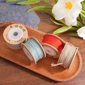 Detail of 1.5mm twisted cotton cords in colorful spools for DIY jewelry on wooden tray