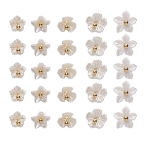 Detailed macro view of white resin flower charms with golden center beads for jewelry