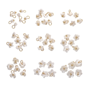Macro view of nine assorted pearlescent resin flower charms with golden bead centers