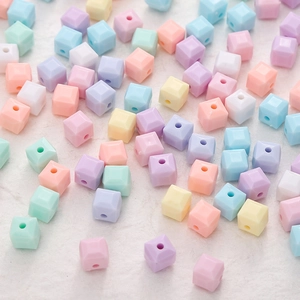 Primer plano de cuentas de cubo de acrílico pastel con facetas para bisutería DIY