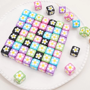 Détail de perles carrées en acrylique colorées avec motif floral et trous pour DIY