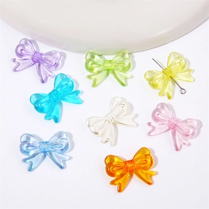 Macro shot of colorful acrylic bow beads for DIY jewelry with metal pin through the center