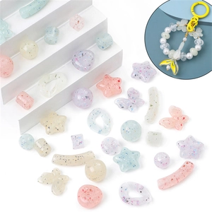 Macro detail of macaron acrylic glitter beads in star and butterfly shapes for DIY jewelry