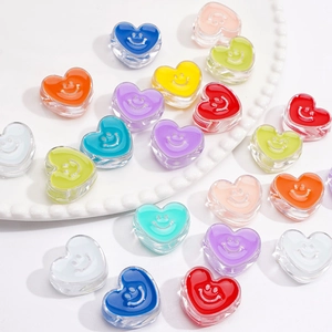 Macro shot of colorful acrylic heart beads with smiley faces for DIY jewelry making