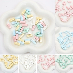 Macro detail of 6x15mm colorful pearlescent ceramic beads for DIY jewelry making and crafts