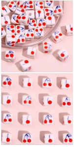 Detailed macro view of 8mm square ceramic beads with hand-painted cherry patterns for DIY