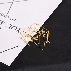 Macro view of bright gold 9-shaped eye pins for DIY jewelry making and beaded earring crafts