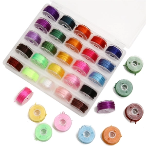 Detailed top view of 25 colorful sewing thread bobbins in a clear storage organizer box