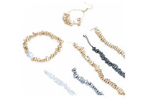 Detailed flat lay of irregular gold beads, grey pearl bracelet and earring DIY components