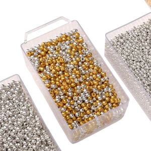 Gros plan de perles métalliques dorées et argentées en boîtes pour bijoux DIY créatifs