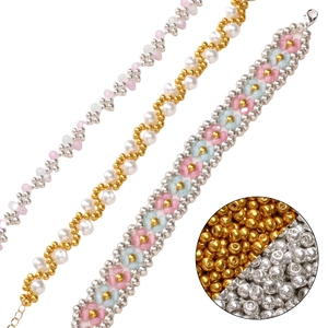 Trois bracelets faits main avec des perles de rocaille en verre or et argent sur fond blanc