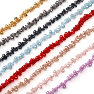 Macro shot of colorful woven beaded lace trims in gold, blue, and red for DIY jewelry