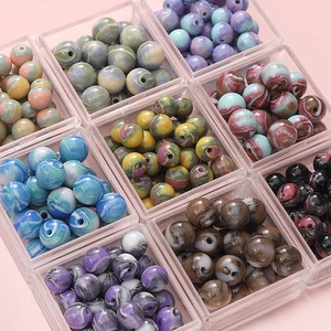 Vue macro de perles rondes en résine à texture marbrée dans des boîtes en plastique