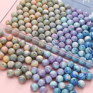 Vue macro de perles rondes en résine à effet marbré pour la création de bijoux DIY