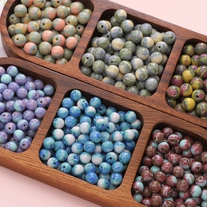 Détail de perles en résine marbrée triées dans une boîte pour création de bijoux DIY