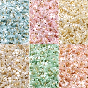 Macro view of assorted pastel pearlized flower pendants with gold metallic rings