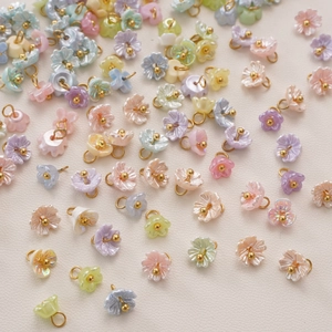 Detailed macro view of colorful resin lily of the valley pendants with gold pearl stamens