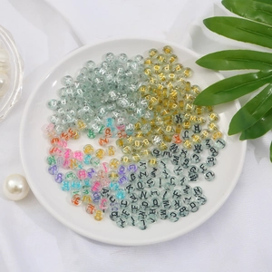 Macro view of clear acrylic alphabet beads with colorful glitter and printed letters