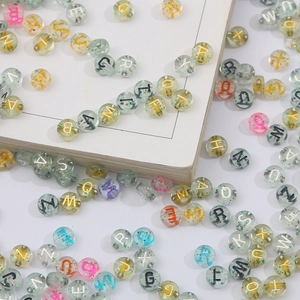 Macro shot of 4x7mm transparent acrylic letter beads with colorful glitter for DIY crafting