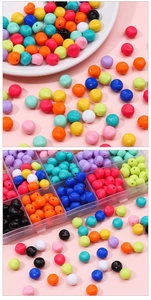 Vue détaillée de perles rondes en acrylique coloré dans une boîte de rangement claire