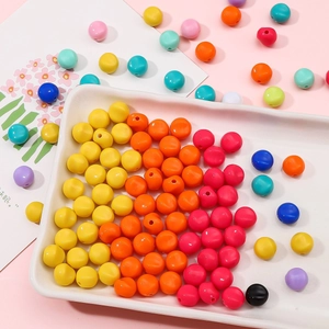 Perles en acrylique colorées pour bijoux DIY, soigneusement disposées dans un plateau blanc