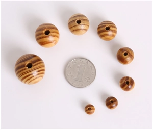Detailed size comparison of polished natural wood beads with coin for scale reference
