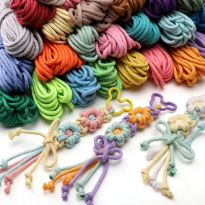 Detail of handmade cotton woven charm with petal shapes, bow tie and metal clasp