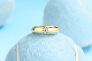 Detail of gold S925 silver ring with marquise-cut moissanite on a blue tennis ball