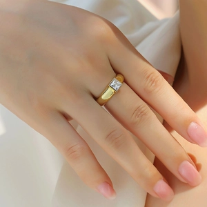 Close-up of a square princess cut moissanite ring set in polished 18K gold band