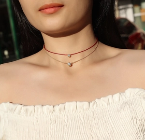 Dettaglio della collana a due strati in argento 925 con cordino rosso e ciondolo moissanite