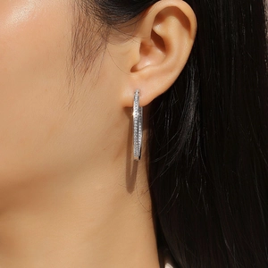 Élégantes créoles en argent 925 avec serti de moissanite portées par un mannequin