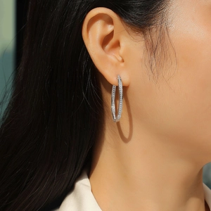 Gros plan de créoles en argent sterling S925 avec moissanite étincelante sur un mannequin