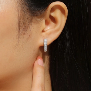 Détail macro de boucles d'oreilles rectangulaires en argent 925 avec micro-pavage de pierres