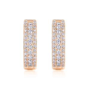 Gros plan de boucles d'oreilles huggies en or rose avec trois rangées de zircons blancs