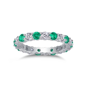 Detailed close-up of emerald and diamond eternity ring in silver prong setting