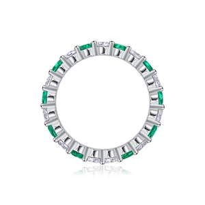 Macro shot of S925 sterling silver eternity band with emerald and cubic zirconia stones
